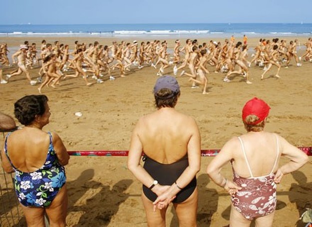 Plażowicze obserwują bieg crossowy nudystów na plaży w Sopelanie (Hiszpania) /AFP
