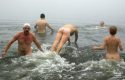 Członkowie klubu "Polarne Wilki z Zehdenick" ciesza się mroźna kąpięlą w jeziorze. Zehdenick, 26 grudnia 2006