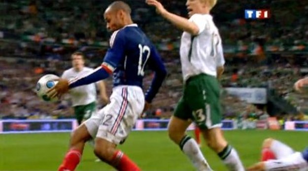 Thierry Henry pomaga sobie ręką przy przyjęciu piłki. Za chwilę pał gol dla Francji. /AFP