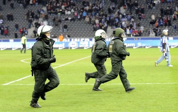 Policja interweniuje po tym, jak kibice Herthy wkroczyli na murawę. /AFP