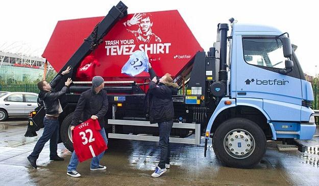 Kibice Man Utd i Man City wrzucają do specjalnej śmieciarki koszulki z nazwiskiem Carlosa Teveza /AFP