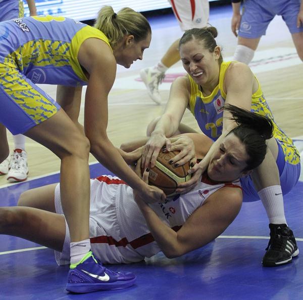 Leżąca na parkiecie z piłką Ewelina Kobryn (C) z Wisły Can-Pack atakowana przez Evę Viteckovą (L) i Viktorię Mirchevą (P) z ZVVZ USK Praga