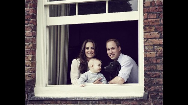 Oto oficjalna fotografia brytyjskiej rodziny - księcia i księżnej Cambridge z synem, księciem George’m. Zdjęcie upubliczniono w sobotę przed wizytą pary w Nowej Zelandii i Australii. 8-miesięczny książę, trzeci w kolejce do tronu, jest na zdjęciu obok rodziców, stojących w oknie ich apartamentu w Kensington Palace w Londynie. George patrzy w kierunku psa, który wabi się Lupo. Zdjęcie zostało zrobione na początku miesiąca przez Jasona Bella. To on stoi także za oficjalnymi fotografiami księcia z jego chrztu, który odbył się w październiku 2013 roku.