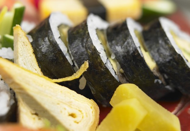 Sushi to obecnie jedno z najmodniejszych dań na świecie. Ten prosty azjatycki przysmak zyskał uznanie dzięki swoim walorom smakowym, ale również estetycznym. Jednak nie każdy fan sushi zna historię powstania tej potrawy.  – Sushi wywodzi się ze sposobu magazynowania żywności. W czasach, kiedy nie było lodówek, ryby magazynowano w chłodnych miejscach, wypychając je czymś, co było nasączone octem – opowiada Artur Andrzejewski, szef kuchni Tekeda Sushi&Ramen. – Za najlepszy nośnik octu uznano ryż, więc nasączano go i wypychano nim ryby, dzięki czemu miały bardzo długi termin przydatności. Z czasem ta forma przechowywania żywności została uznana za potrawę – daje. Oprócz historii powstania sushi Artur Andrzejewski zdradził również, jak je dobrze przyrządzić.