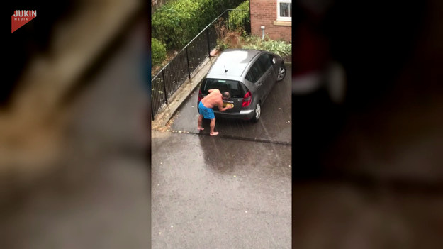 Niecodzienny widok na jednej z angielskich ulic. Mężczyzna wykorzystał deszcz do... umycia samochodu. Co o tym sądzicie?
