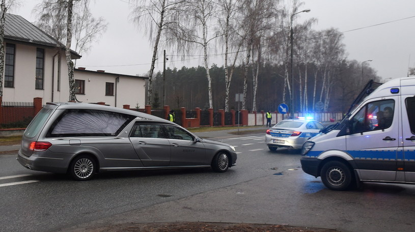 Karawan w asyście wozów policyjnych opuszcza cmentarz w Marysinie Wawerskim przy ul. Korkowej w Warszawie /Radek Pietruszka /PAP