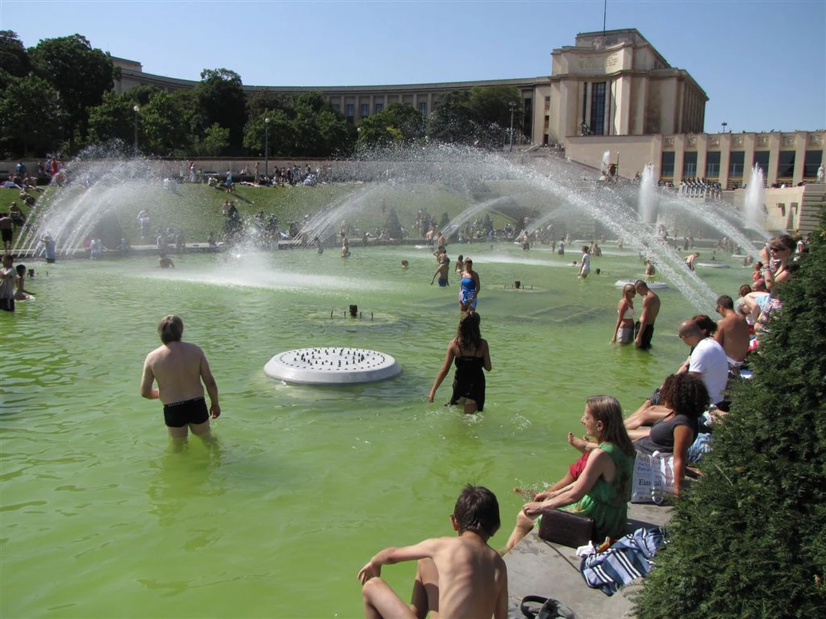 Wielkie szaleństwo pod Wieżą Eiffla. Z powodu rekordowych upałów w Paryżu, gdzie temperatura sięga blisko 40 stopni Celsjusza - tłumy mieszkańców i turystów oblegają fontanny koło tego zabytku.
