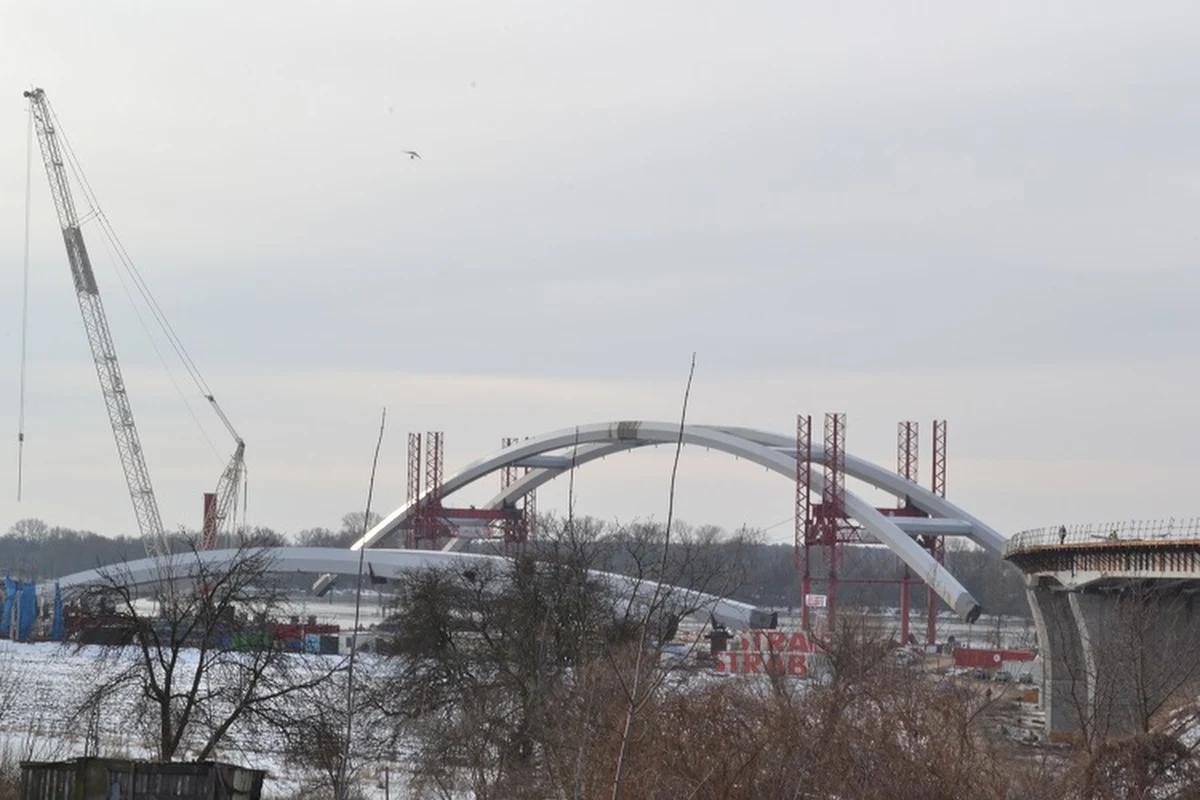 W Toruniu rozpoczyna się montaż największych w Polsce łuków mostowych – kluczowy i najbardziej spektakularny etap budowy nowej przeprawy przez Wisłę w Grodzie Kopernika. Dwa gigantyczne przęsła mają po 270 metrów długości, 50 wysokości i ważą 2,7 tys. ton. To pierwsza w kraju akcja montażowa na taką skalę, bardzo rzadko spotykana w Europie i na świecie.