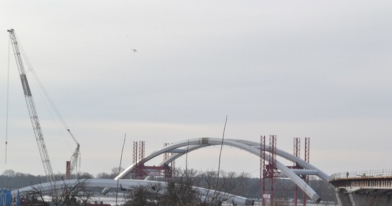W Toruniu rozpoczyna się montaż największych w Polsce łuków mostowych – kluczowy i najbardziej spektakularny etap budowy nowej przeprawy przez Wisłę w Grodzie Kopernika. Dwa gigantyczne przęsła mają po 270 metrów długości, 50 wysokości i ważą 2,7 tys. ton. To pierwsza w kraju akcja montażowa na taką skalę, bardzo rzadko spotykana w Europie i na świecie.