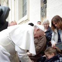 Papież Franciszek podpisuje się na gipsie niepełnosprawnej dziewczynki [PAP/EPA/L'Osservatore Romano]
