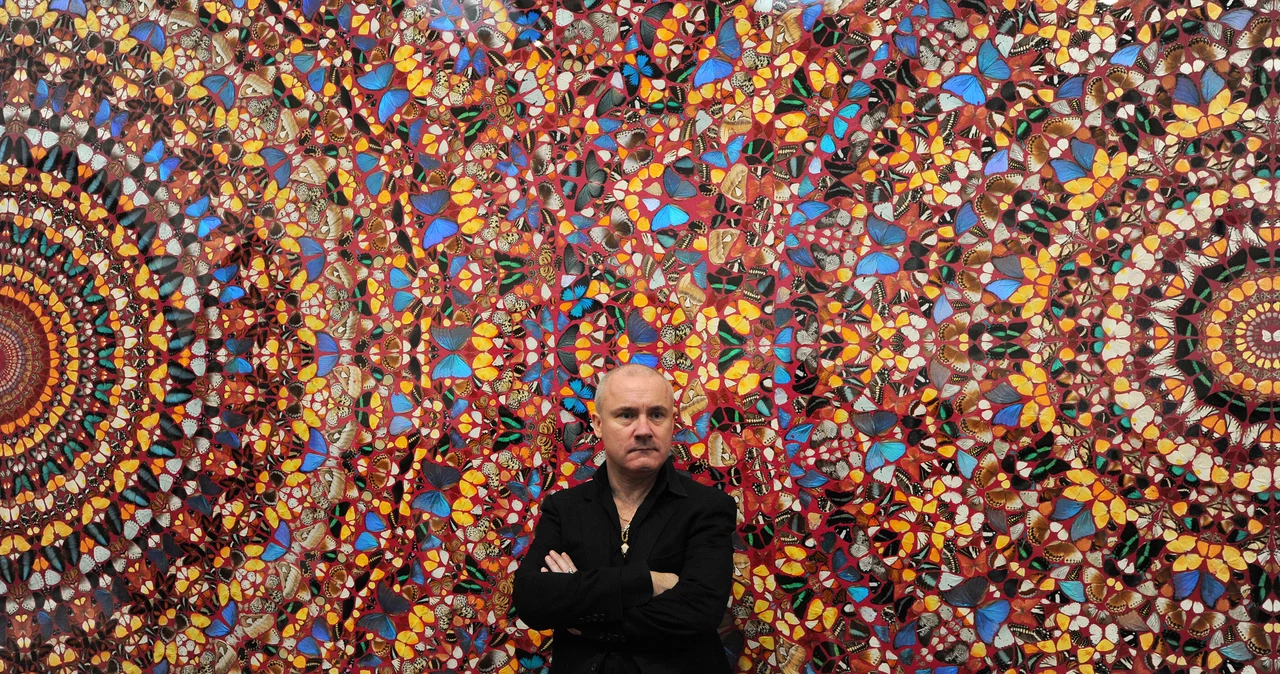 Na zdjęciu Damien Hirst przed jednym ze swoich obrazów