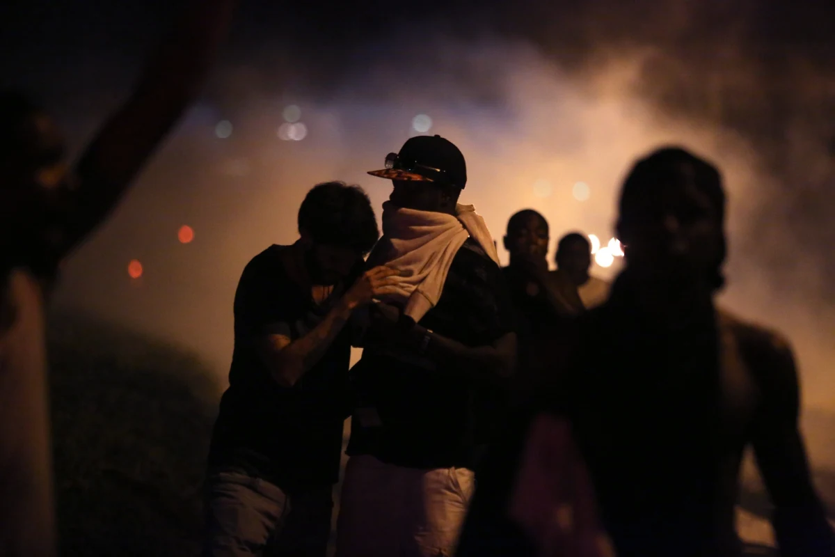 Policja w Ferguson na przedmieściach St. Louis użyła gazu łzawiącego wobec demonstrantów. O północy przedłużono godzinę policyjną ogłoszoną po zamieszkach, które wybuchły, gdy biały policjant zabił nieuzbrojonego czarnoskórego nastolatka. 