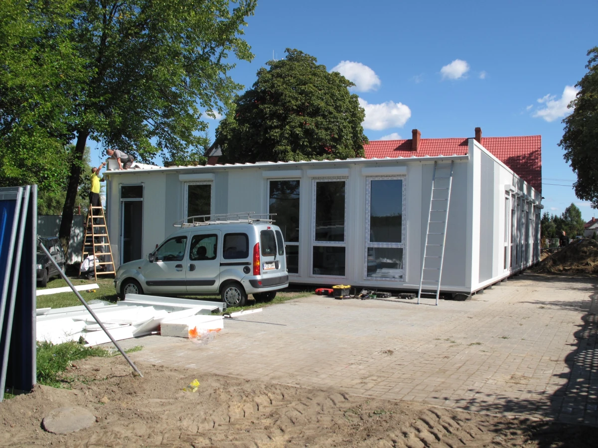 Szkoła z kontenerów powstaje w podpoznańskiej Dąbrowie. To pomysł dyrektorki szkoły i dwojga rodziców, którzy w ten sposób zareagowali na informację o tym, że gmina Dopiewo planowaną na 2015 rok rozbudowę szkoły przesunęła o kilka lat. W wyniku burzy mózgów - jak twierdzą pomysłodawcy - powstał pomysł ustawienia modułów.