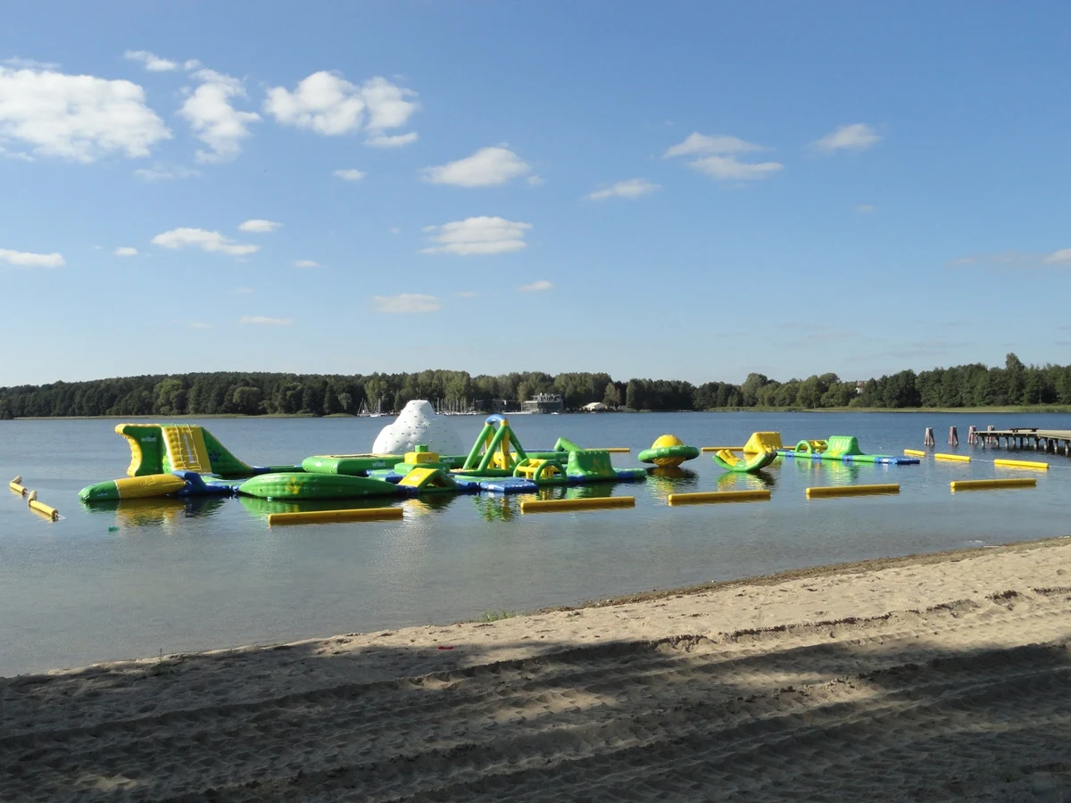 Na olsztyńskim jeziorze Krzywym trwają testy wodnego placu zabaw. To gigantyczna, dmuchana konstrukcja, która składa się m.in. z katapult, skoczni i przeszkód. Pływający plac zabaw w Olsztynie będzie największym takim obiektem w kraju.