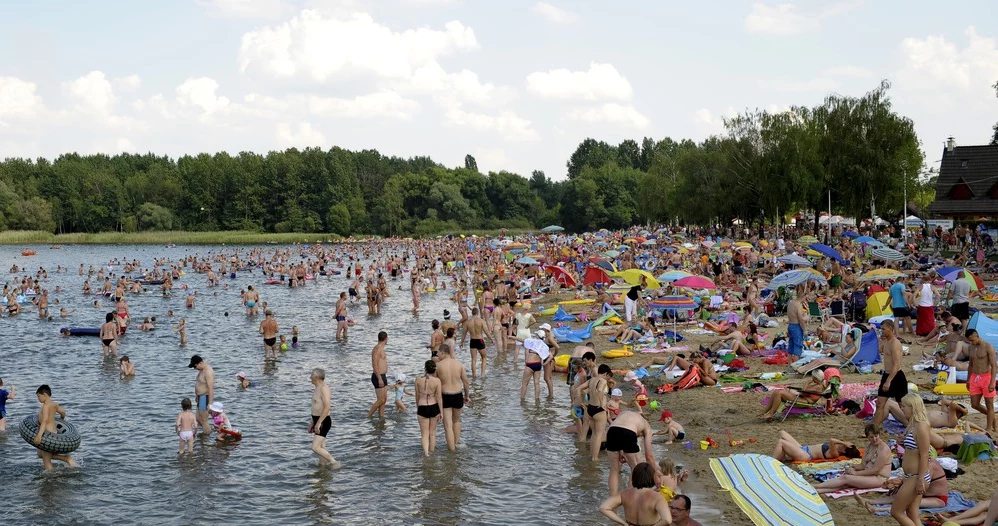 Tłumy ludzi odpoczywają nad zbiornikiem wodnym (Kąpielisko Pogoria III)