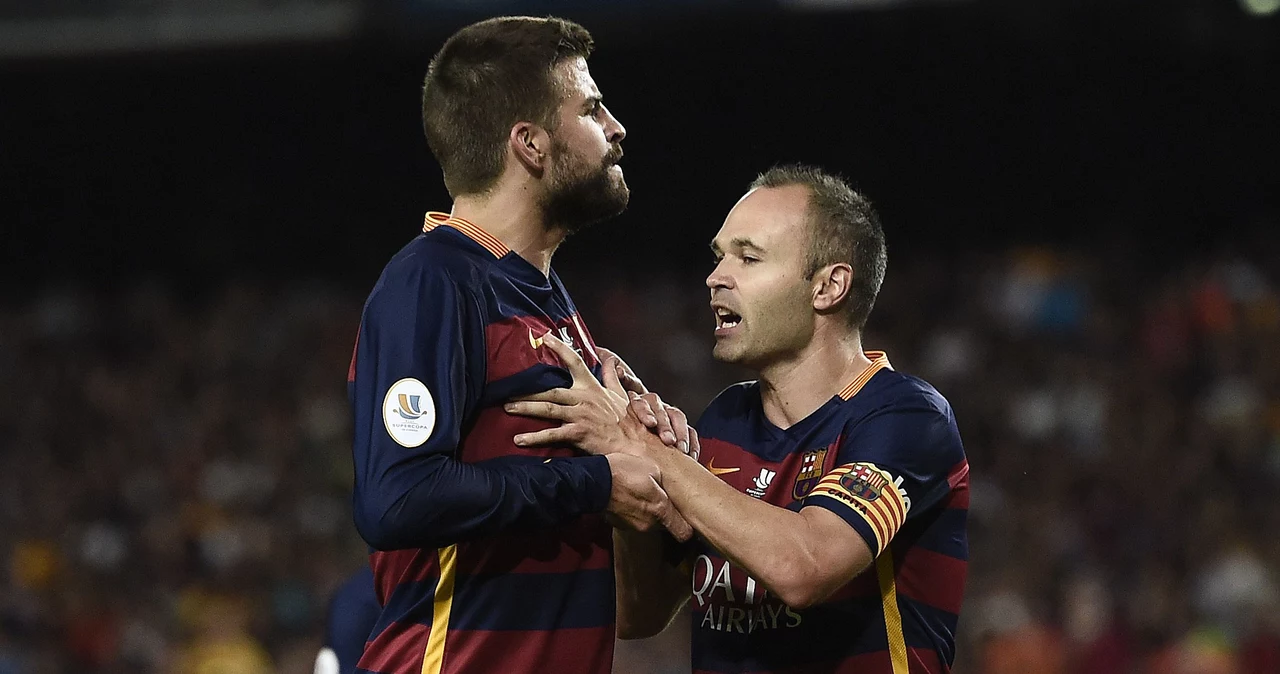 Andres Iniesta powstrzymuje zdenerwowanego Gerarda Pique