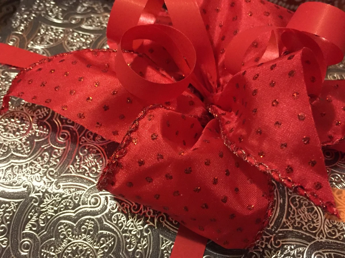 Kluczem do tego, żeby podarunek był atrakcyjny, jest ozdobny papier oraz dekoracyjna wstążka. Nie trzeba kupować gotowej kokardy, ale można ją wykonać samodzielnie – tak będzie taniej i bardziej oryginalnie. Wstążka może być syntetyczna lub materiałowa. Nawet kawałki tekstyliów z brokatem lub tiulowe – odpowiednio przycięte – mogą być doskonałą kokardą. Do ozdobienia prezentu można także wykorzystać szyszki i dołożyć gałązki świerkowe czy jodłowe. Jak zapakować prezent pod choinkę w prosty sposób, możecie zobaczyć na naszym filmie i zdjęciach. 