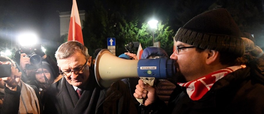 ​Zwolennicy KOD, którzy w nocy z piątku na sobotę kontynuowali protest pod Sejmem przeszli w marszu wokół sejmowych gmachów. Wcześniej zablokowali wyjścia z Sejmu uniemożliwiając posłom wyjazd samochodami. Kilkadziesiąt osób wciąż jest przed Sejmem. 