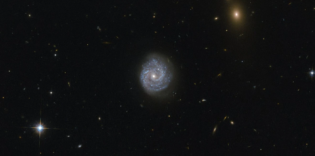 Agencje NASA i ESA opublikowały piękne zdjęcie galaktyki RX J1140.1+0307, widocznej w gwiazdozbiorze Panny i oferującej astronomom interesującą zagadkę. Na pierwszy rzut oka obiekt ten wydaje się zwyczajną, podobną do Drogi Mlecznej galaktyką spiralną. Bliższe spojrzenie pokazuje jednak, że coś z nim jest nie tak. Nie bardzo da się wyjaśnić obserwowaną jasnośc jądra tej galaktyki.