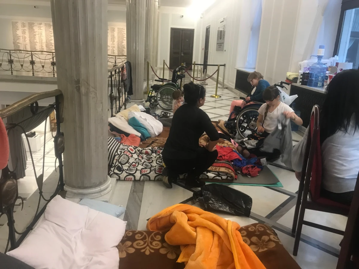 "Od ponad tygodnia nie wychodziliśmy na zewnątrz. Czujemy, że damy radę jeszcze tak funkcjonować" - mówią w rozmowie z reporterem RMF FM protestujący opiekunowie osób niepełnosprawnych. To już ósmy dzień pikiety kilkunastu osób na sejmowych korytarzach. Ich główny postulat to 500 złotych dodatku rehabilitacyjnego dla każdej osoby z niepełnosprawnością w Polsce. Przed gmachem Sejmu na Wiejskiej o 10:00 rozpocznie się pikieta poparcia dla protestujących. Według organizatorów, może wziąć w niej udział kilka tysięcy osób. 