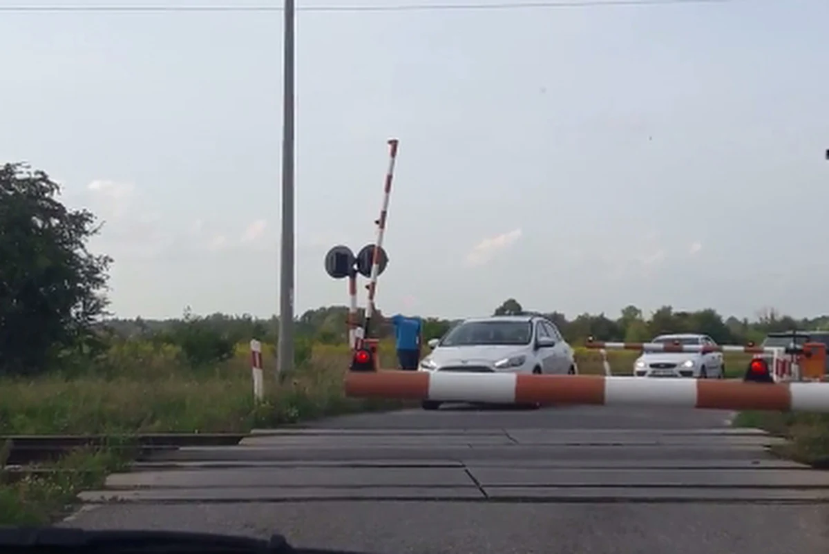 ​Policja w Radomiu opublikowała nagranie, jakie otrzymała od jednej z internautek. Na filmie widać kierowcę, który podnosi szlaban i umożliwia innym wjechanie na przejazd kolejowy, tuz przed pociągiem. "To skracanie sobie drogi do śmierci" - podkreślają policjanci i kolejarze. Kierowcy, którzy złamali przepisy zostali już ustaleni. Jednocześnie PKP Polskie Linie Kolejowe będą domagały pokrycia kosztów naprawy rogatki od mężczyzny, który tego dokonał.