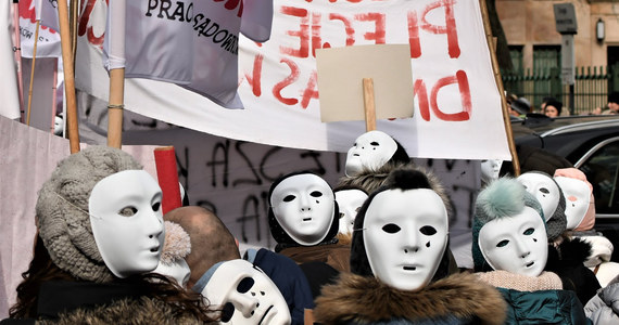 Kilka tysięcy pracowników sądów i prokuratur manifestuje na ulicach Warszawy, domagając się podwyżek płac: w tym roku jeszcze o 450 złotych na rękę. Na transparentach widać hasła jak "Dość pracy za grosze" czy "Nie jesteśmy niewidzialni", a na twarzach protestujących… teatralne, płaczące maski. To - jak mówią pracownicy sądów i prokuratur - ironiczny komentarz do ich sytuacji.