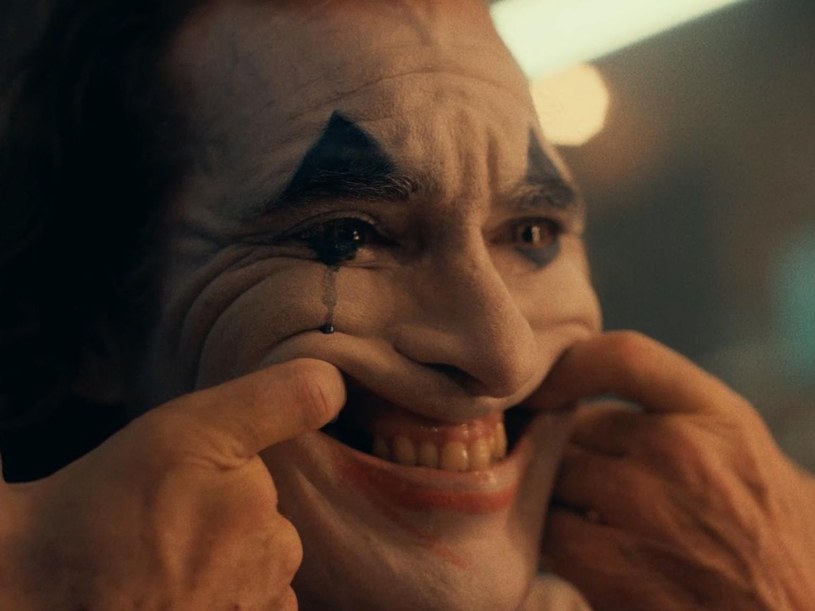 "Mama zawsze mi powtarzała: 'Uśmiechaj się i nadrabiaj miną'. Według niej mam w życiu cel. Rozśmieszać i nieść radość" - tymi słowami zaczyna się zapowiedź filmu "Joker". W tytułową postać wciela się Joaquin Phoenix. Czy odkryje przed widzem tajemnicę zabójczego uśmiechu Jokera?