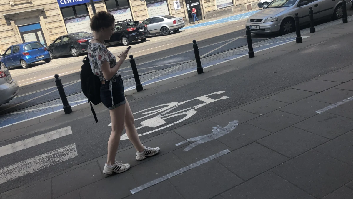 Specjalny pas dla wpatrzonych w telefony pojawił się na chodniku przy ulicy Nowowiejskiej, w centrum Warszawy, niedaleko Politechniki Warszawskiej. To inicjatywa mieszkańców, którzy wydzielili przerywanymi liniami fragment trasy, na którym oczy można mieć skierowane w smartfon.