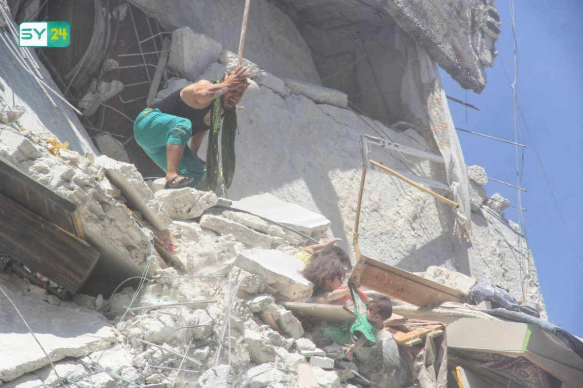 5-letnia dziewczynka przysypana gruzami zbombardowanego domu desperacko próbuje uratować przed upadkiem 7-miesięczną siostrzyczkę, trzymając ją za koszulkę. I dramatyczny moment, gdy obie spadają z wysokości piątego piętra. Zdjęcie zrobione w zbombardowanym mieście Ariha stało się symbolem tragicznego losu syryjskich dzieci.