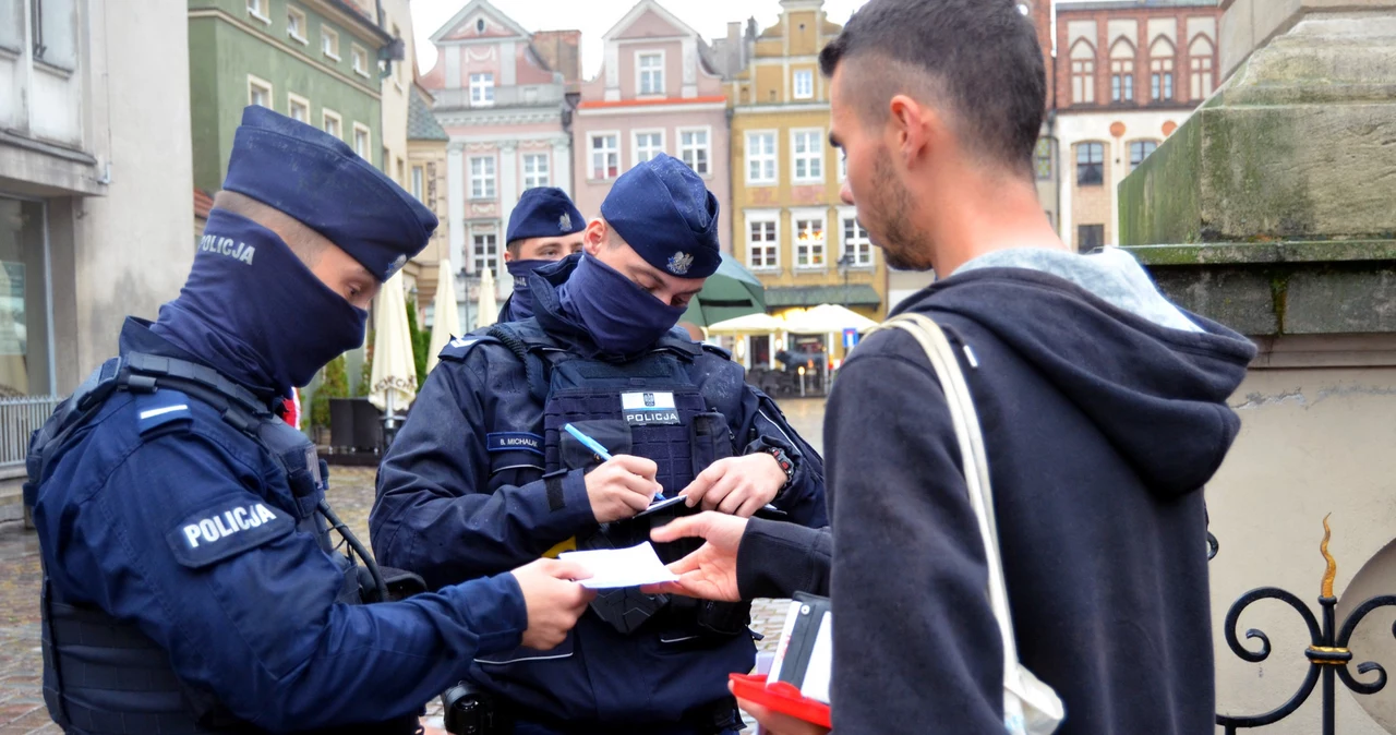 "Marsz o wolność" w Poznaniu organizowany przez środowiska antyszczepionkowców i antycovidowców. Policjanci wypisują mandat za brak maseczki