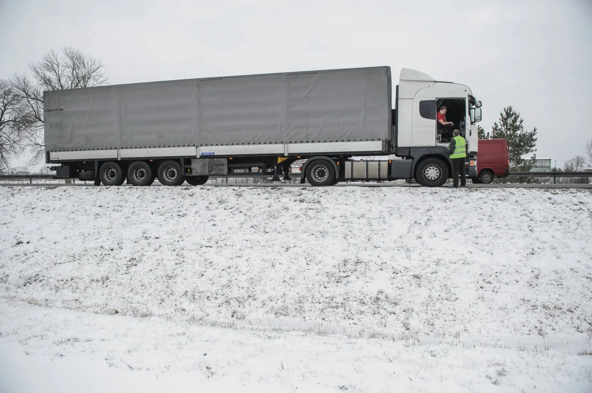 Temperatura poniżej zera i opady deszczu to warunki, które mogą doprowadzić do niebezpiecznych sytuacji na drogach. Chodzi o zalegający lód na dachach samochodów ciężarowych. Spadające grudki twardego śniegu, czy wręcz tafle lodu, stanowią poważne zagrożenie dla innych uczestników ruchu. Za nieodśnieżony pojazd grożą wysokie mandaty. Kierowcy ciężarówek zwracają jednak uwagę na inny problem…