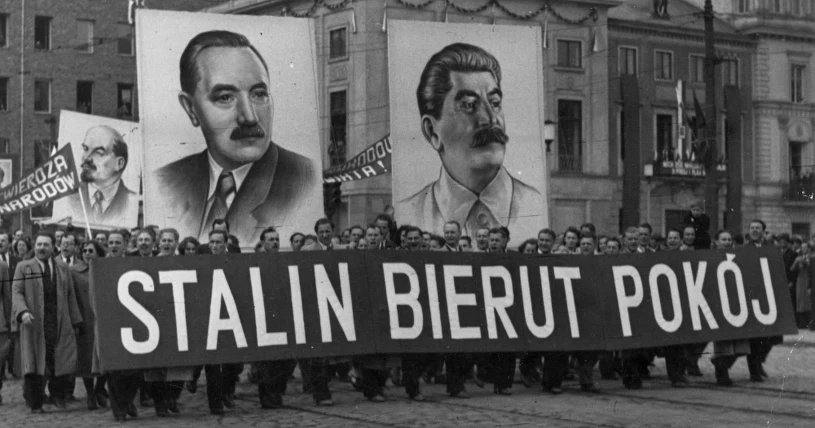 Ludzie w manifestacji niosą wielkie portrety Bieruta, Stalina i Lenina, oraz ogromny materiał z napisem "Stalin Bierut Pokój".