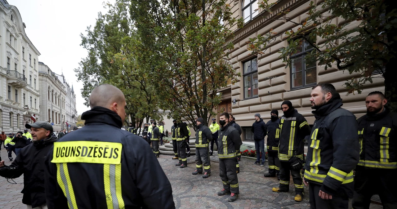 Strażacy protestują przeciwko obowiązkowym szczepieniom przeciw COVID-19 przed budynkiem parlamentu Łotwy