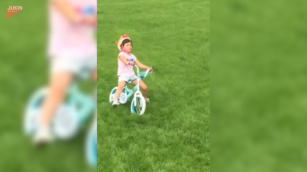 Ta urocza dziewczyna próbowała swojego pierwszego zjazdu na rowerze, kiedy wydarzyło się coś nieoczekiwanego. Podczas jazdy straciła równowagę i upadła wprost na trawę. Na szczęście dziewczynce nic złego się nie stało - poza dużym rozczarowaniem upadkiem.
