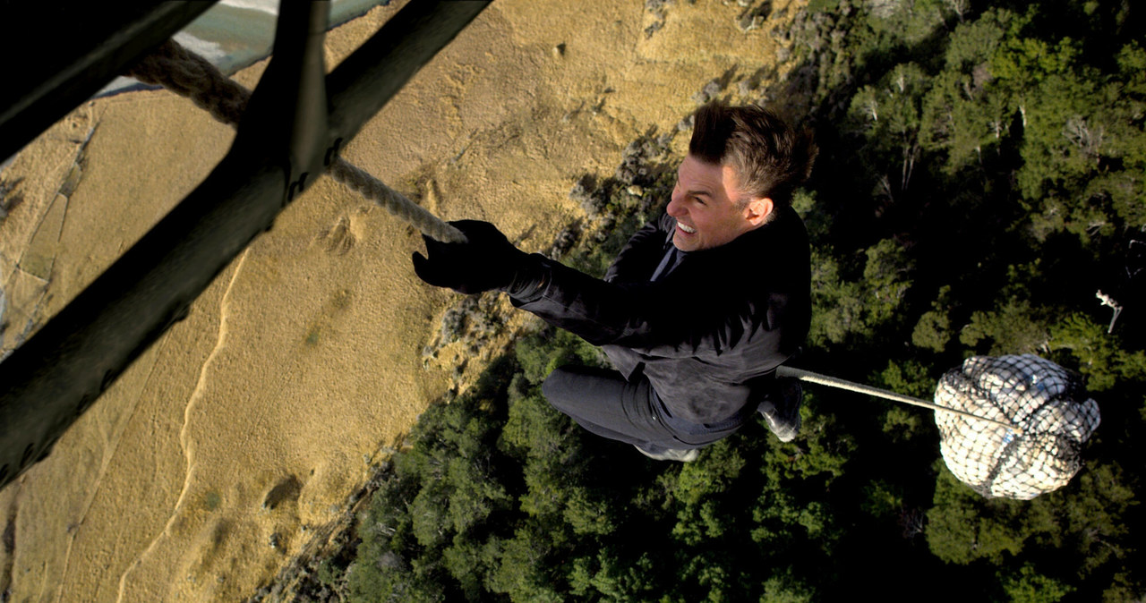 Choć niedawno skończył 60 lat, nie ma zamiaru kończyć z wyczynami kaskaderskimi. Tom Cruise, który słynie z tego, że samodzielnie wykonuje akrobacje w swoich filmach, został właśnie sfotografowany na planie kolejnej części "Mission: Impossible" w Wielkiej Brytanii. Scena, w której występował, wymagała od niego stalowych nerwów i ogromnej sprawności. Aktor musiał bowiem zlecieć na paralotni ze szczytu jednej z gór.