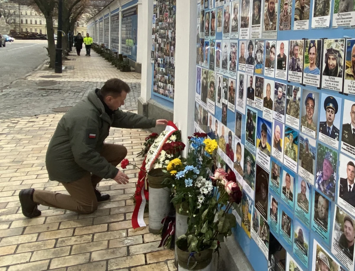 "Wicepremier, szef MON Mariusz Błaszczak nie składał kwiatów ani nie klękał przed flagą UPA; złożył wiązankę pod ścianą poległych w Kijowie, w miejscu, w którym hołd składają wszystkie zagraniczne delegacje" - przekazało w sobotę MON. Jak zaznaczono, flaga UPA znajdowała się w sąsiedniej części muru.