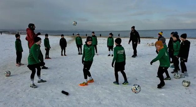  Napastnik Lechii Gdańsk Łukasz Zwoliński gra w piłkę na plaży z młodymi adeptami klubowej akademii.