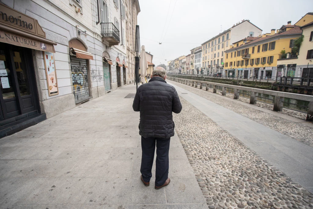 Lockdown w trakcie pandemii COVID-19. Samotny mężczyzna w pobliżu kanału Naviglio Grande w Mediolanie