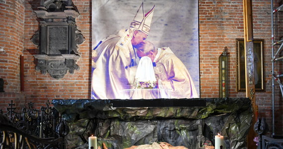 Archiwalne zdjęcie wykonane podczas inauguracji pontyfikatu Jana Pawła II, na którym widnieje papież i kardynał Stefan Wyszyński umieszczono przy grobie Pańskim w parafii pw. św. Brygidy w Gdańsku. Na zdjęciu widnieje napis: Idziemy za krzyżem, aby wygrać życie.