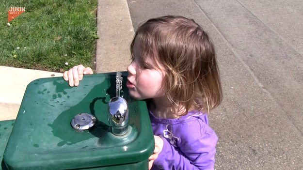 Co zrobić, gdy jest się za niskim, by skorzystać z dyspozytora wody? Na to pytanie próbuje odpowiedzieć ta dziewczynka. 