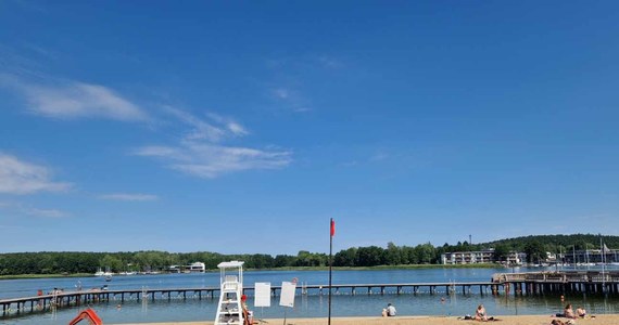 Zakaz kąpieli na kąpieliskach miejskich na jeziorze Ukiel w Olsztynie. Czerwona flaga powiewa tam z powodu podejrzenia zakwitu sinic.