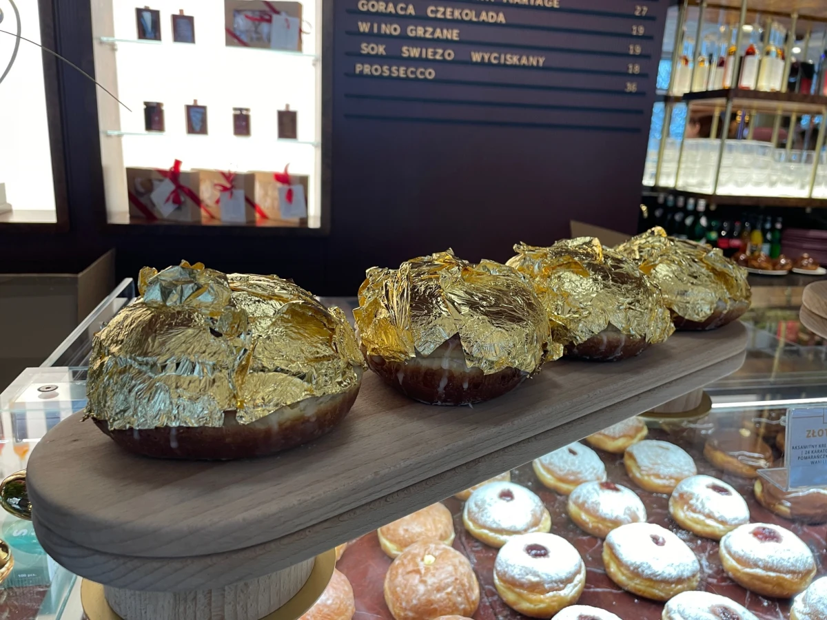 „Doświadczenie wszelkimi zmysłami, wejście w filozofię omni sens, czyli zarówno posmakować, jak i doświadczyć wzrokiem” – tak o złotym pączku mówi autor słodkości wartej 100 zł. W siedmiu miastach w Polsce można kupić dziś pączka pokrytego 24-karatowym złotem.