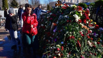 Grób Nawalnego przykryty kwiatami. Przed cmentarzem gigantyczna kolejka osób