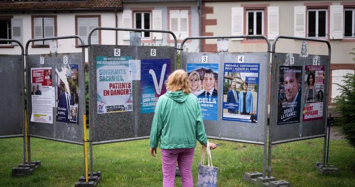 Wybory we Francji. Wyborczyni przed plakatami kandydatów