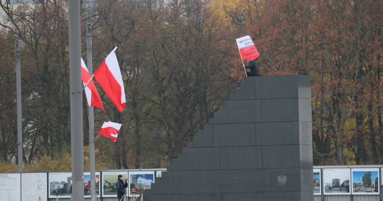 Mężczyzna z polską flagą wszedł na pomnik smoleński