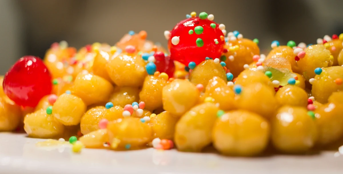 Jest słodki, kolorowy i bardzo apetyczny. Nie musisz być mistrzem kuchni, by szybko go przygotować i zachwycić bliskich przy świątecznym stole. Struffoli to deser, który kochają Włosi. Jak go zrobić? Rozmawialiśmy o tym z Katarzyną Cehańczuk - Polką od 30 lat mieszkającą koło Neapolu. 