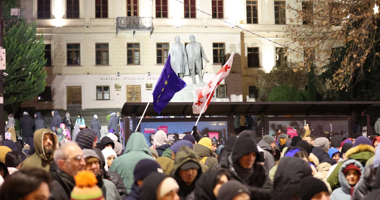 Demonstranci z flagami UE i Gruzji przed parlamentem w Tbilisi, gdzie od tygodni trwają wieczorne protesty