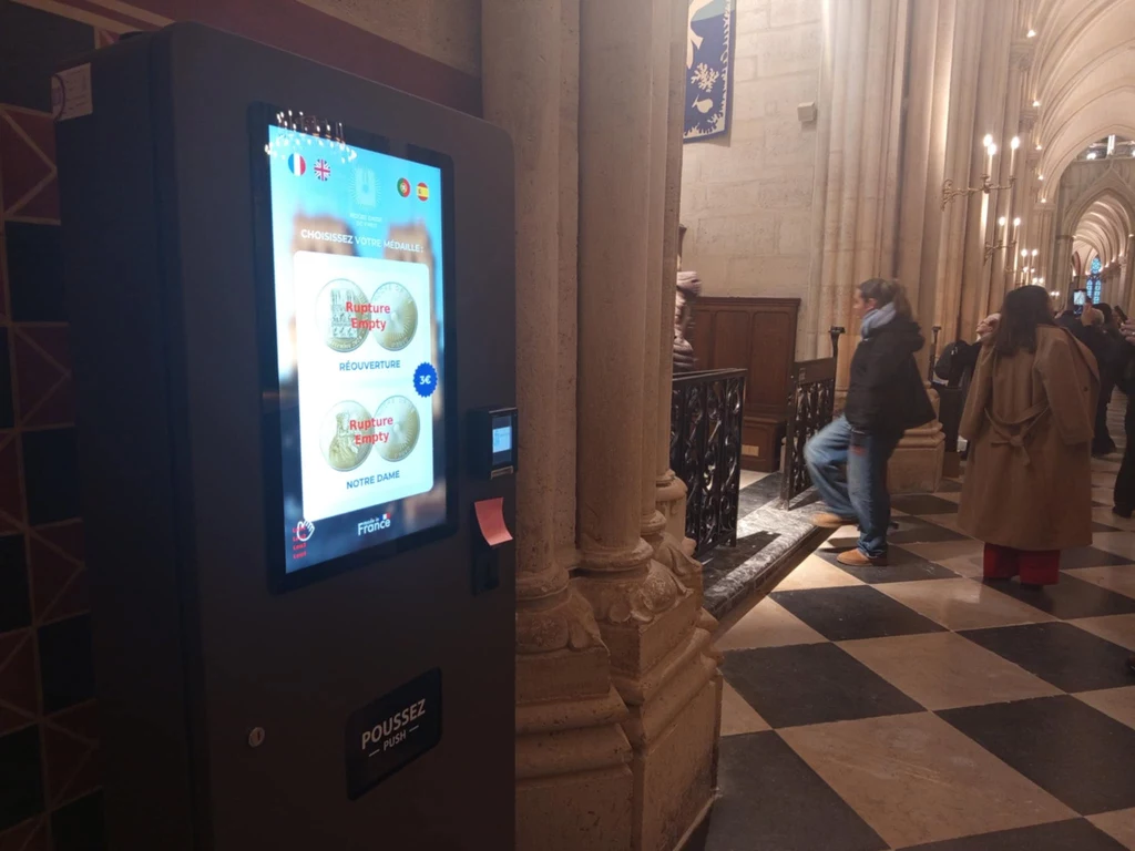 Automat z pamiątkowymi monetami we wnętrzu Notre Dame