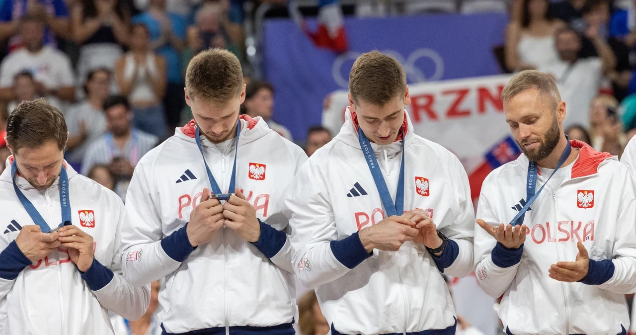 Grzegorz Łomacz (z lewej) wraz z kolegami ogląda srebrny medal olimpijski  