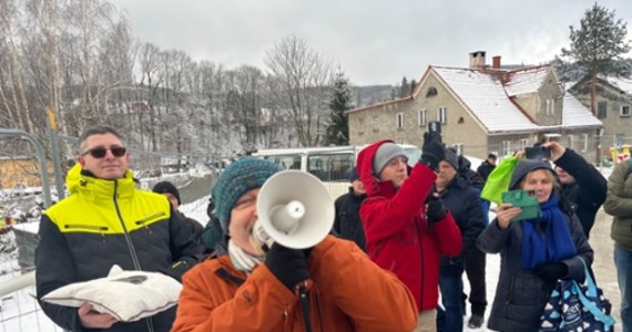 Czujemy się oszukani, miarka się przebrała - skandowali dziś mieszkańcy Stronia Śląskiego, którzy zorganizowali happening przy zniszczonym przez powódź moście wojewódzkim. Urząd Marszałkowski obiecał, że postawi w jego miejscu tymczasowy - do końca grudnia. Tymczasem przeprawy wciąż nie ma. Tłum mieszkańców pojawił się na miejscu z symboliczną wstęgą.